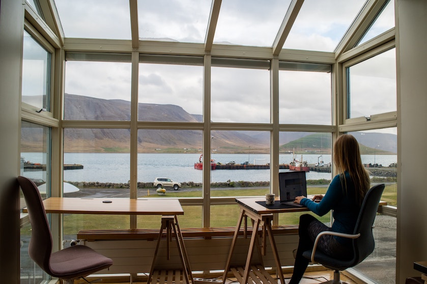 A woman sits at her desk in front of a window.