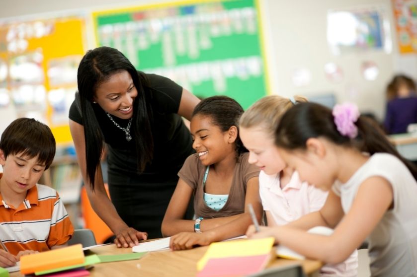 female teacher interacting with a group of young students